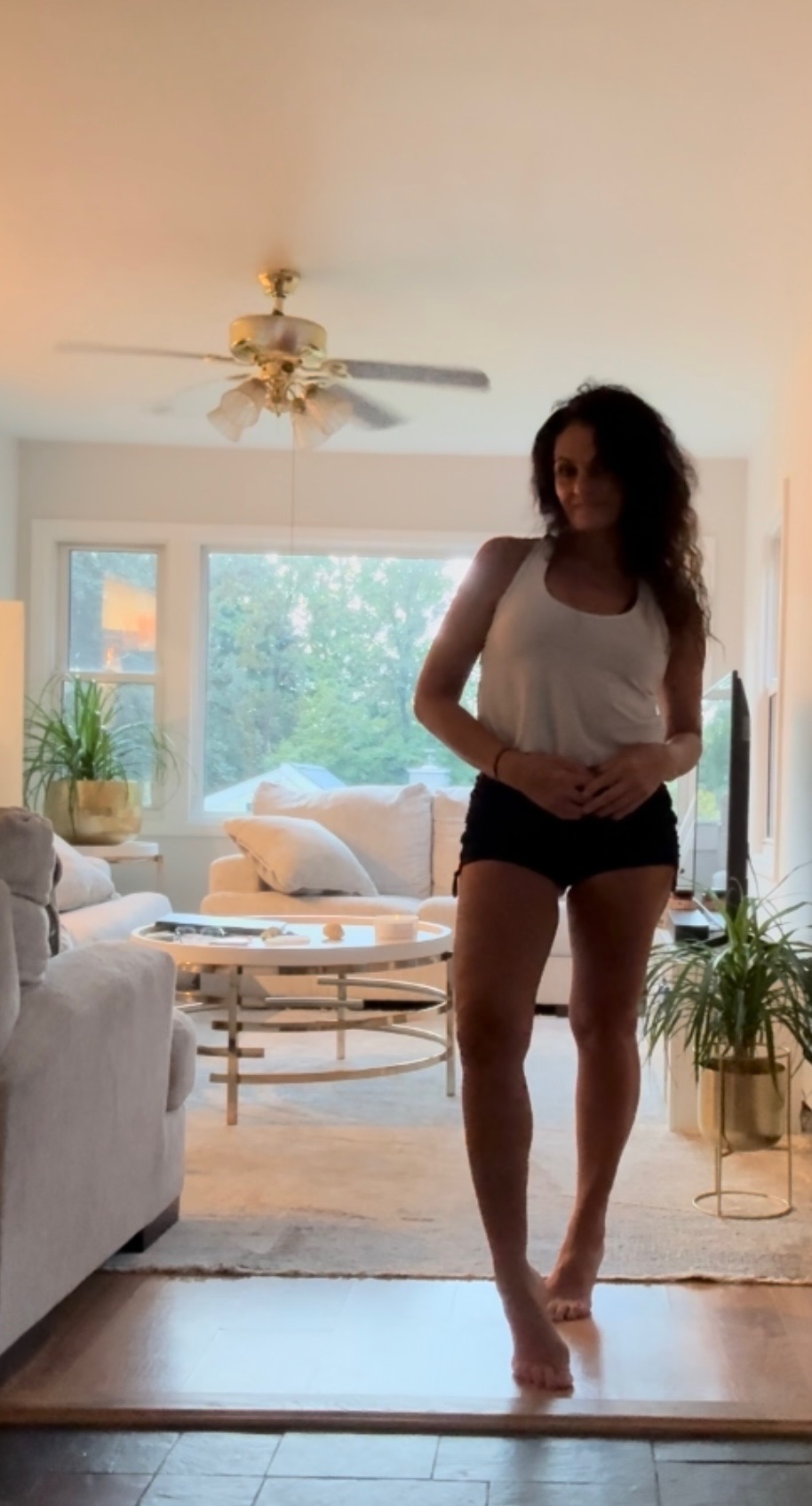 Darlene Cook standing barefoot in warm afternoon window light